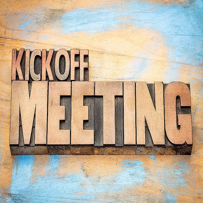 Kickoff meeting word abstract in letterpress wood type printing blocks against grunge wooden surface